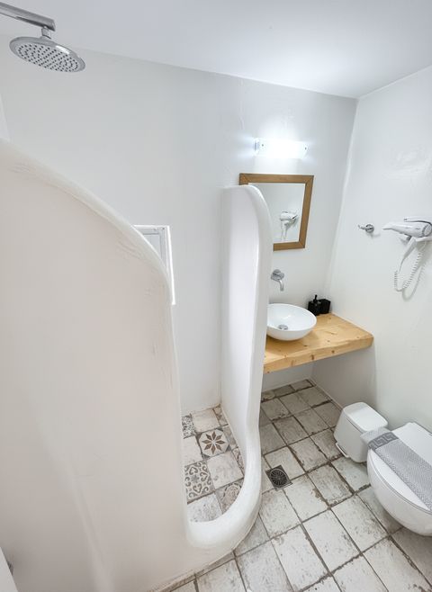 Bathroom with rain shower, wooden-framed mirror, hairdryer and wall-hung toilet